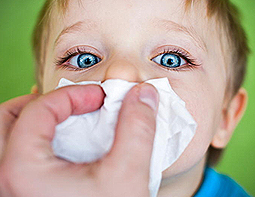 Child wiping the nose with tissue