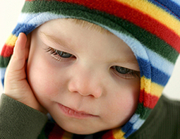 Image of a child wearing a colourful bonnet